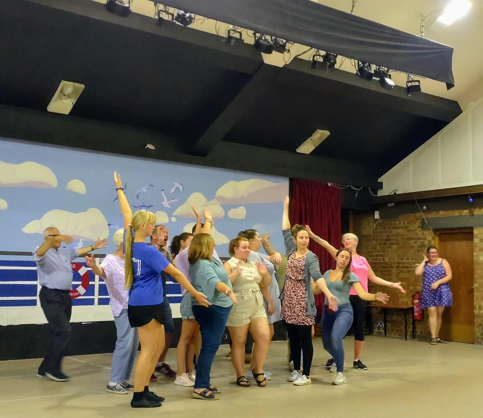 Members of the cast learning the dance to the opening number