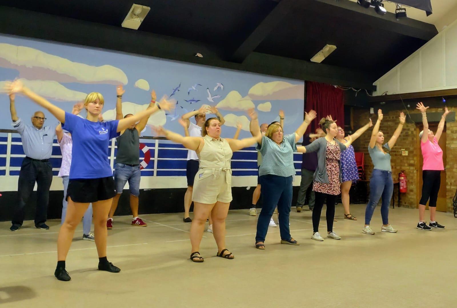Members of the cast learning the dance to the opening number